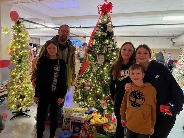 L-R: Jacqueline, James, Hazel, Evelyn and Lawrence Paradis,
enjoying a family night out, stand in front of the tree donated by Cabana’s Auto Body