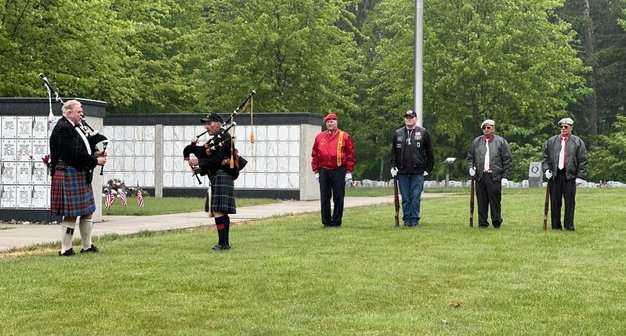 Pipers Al Halliday and Bill Ferrigno play while the Rifle Guard from Amvets Post 3 stands ready