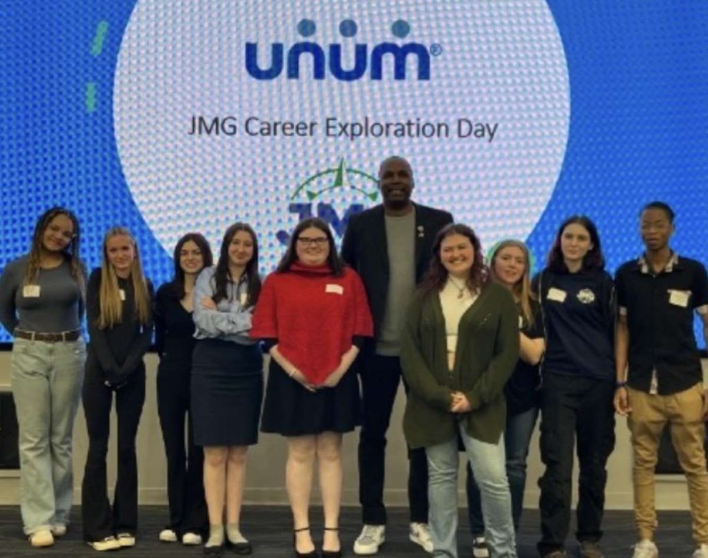 Dajuan Eubanks, president of the Maine Celtics, poses with Jobs for Maine Graduates students at a career day event in Portland.